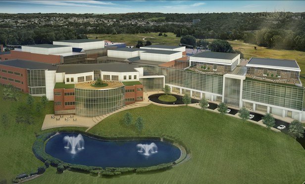 An aerial view of the exterior of the 1-million-square foot Discovery Labs in Upper Merion, PA showing a very large glass and brick building on a landscaped campus